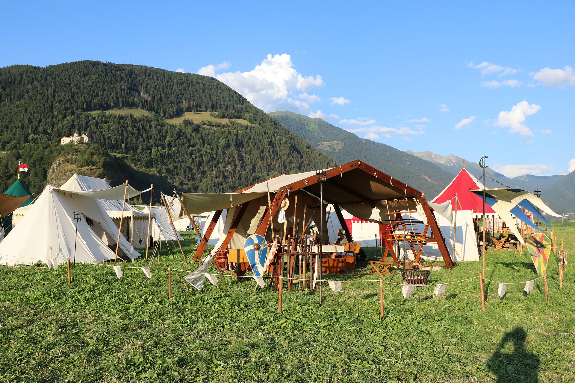 Claymore Lagerleben: Zelte und Waffenständer vor Bergpanorama