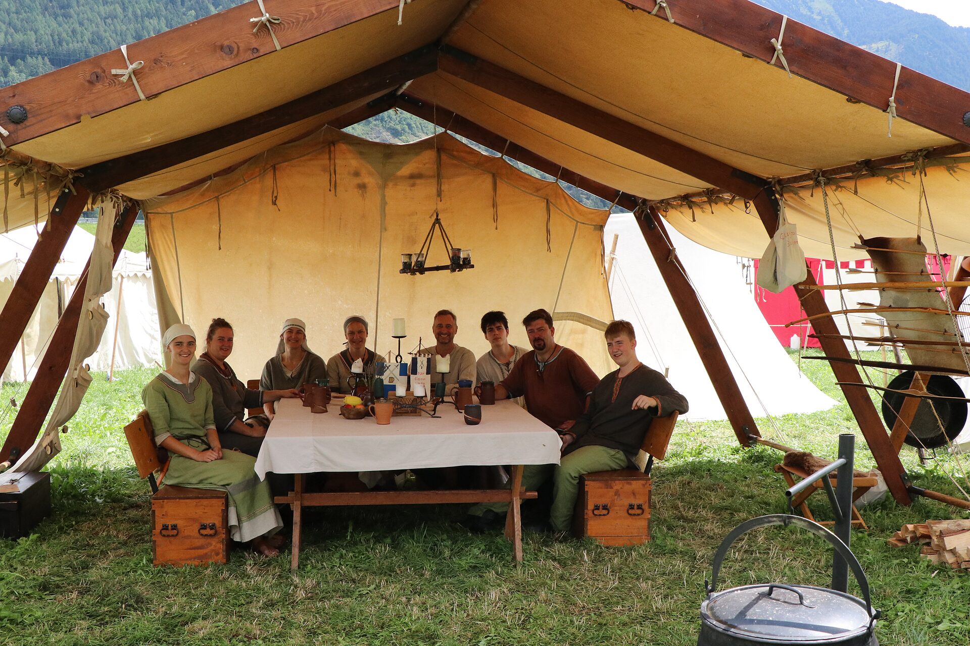 Gemeinsames Mahl an der Tafel unter dem Lagerzelt